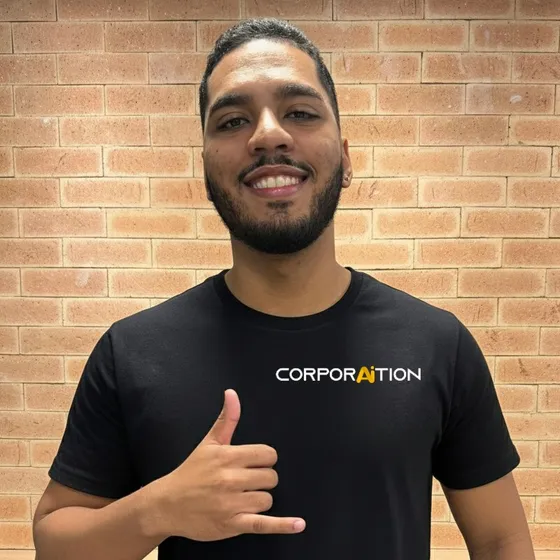 Integrante da equipe Corporaition fazendo sinal de hang loose, de camiseta preta com a marca