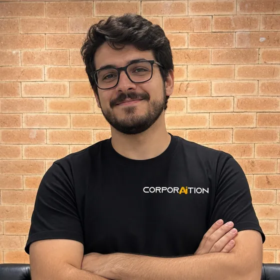 Integrante da equipe Corporaition de braços cruzados, de camiseta preta com a marca